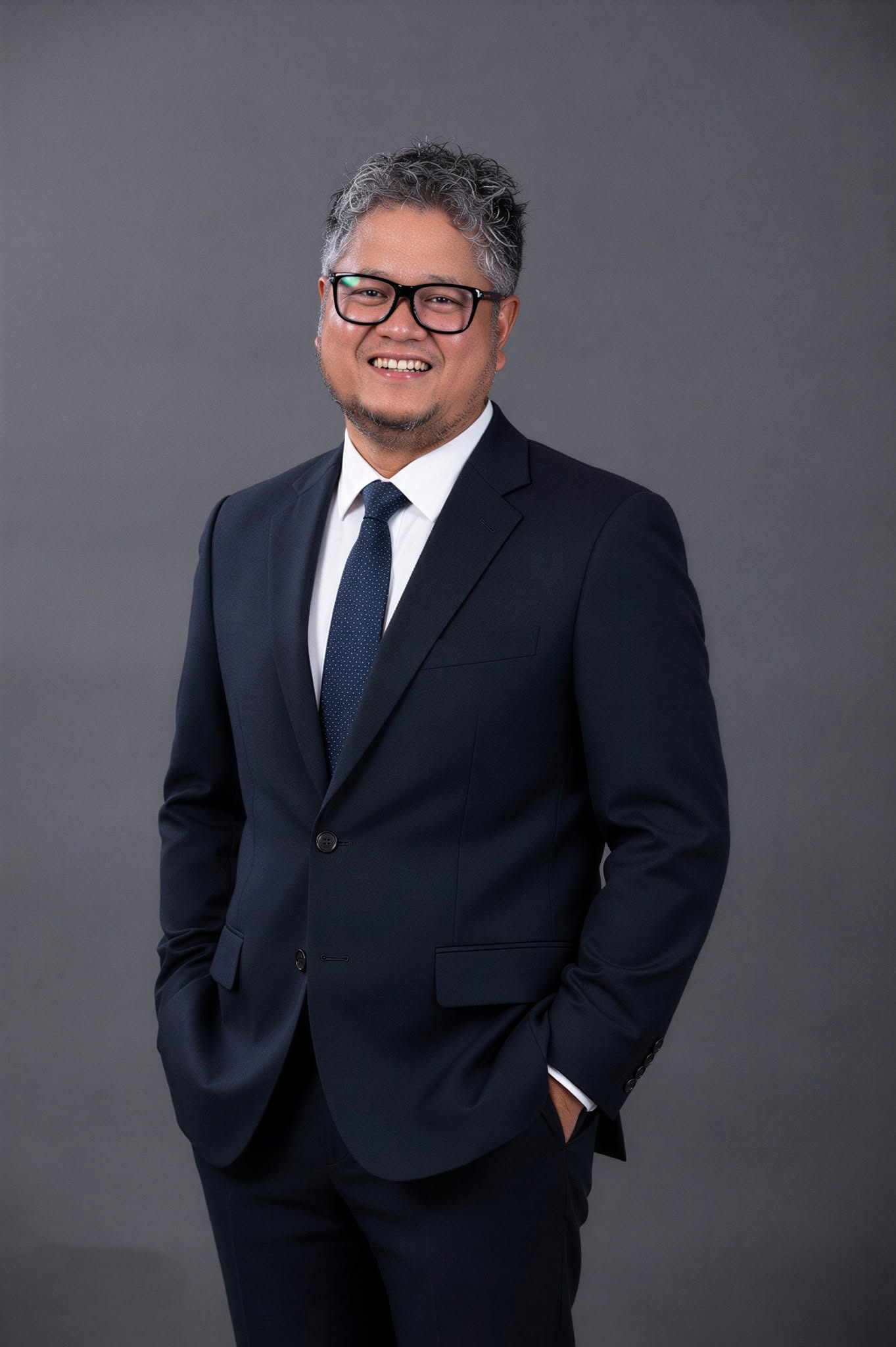 Formal portrait of Rovic Cruz in a navy suit and tie